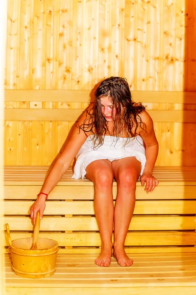 Young woman with brown hair enjoying sauna wellness. — Stock Photo, Image