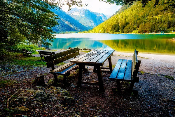 Bela paisagem. Banco de madeira com vista para o lago e montanhas . — Fotografia de Stock