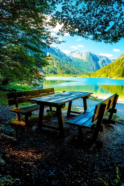 Деревянные скамейки и стол с удивительным видом на озеро . — стоковое фото