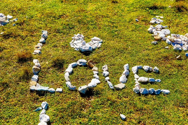 Palavra amor feito de pedras de seixo no prado da montanha . — Fotografia de Stock