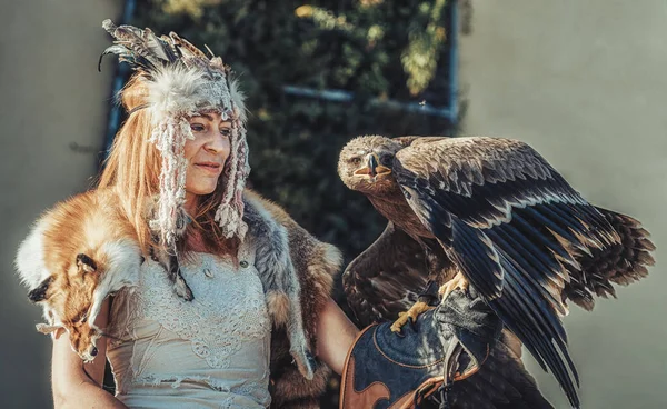 Mooie sjamanistische vrouw met adelaar in de natuur. — Stockfoto