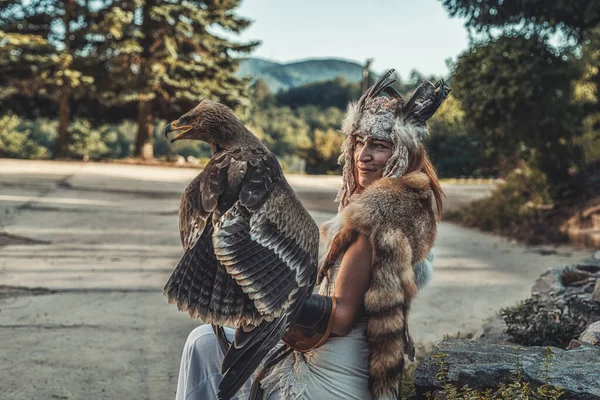 Hermosa mujer chamánica con águila en la naturaleza. — Foto de Stock