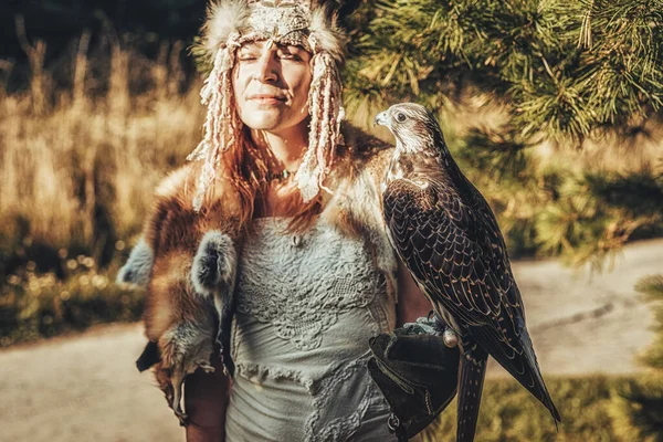 Schöne schamanische Frau mit Adler in der Natur. — Stockfoto