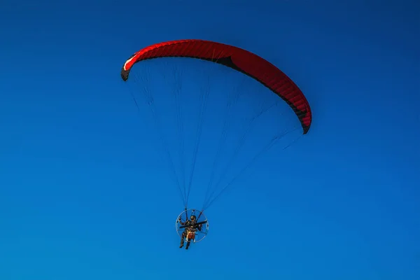 Αλεξίπτωτο πλαγιάς στον αέρα, όμορφο γαλάζιο ουρανό στο παρασκήνιο. — Φωτογραφία Αρχείου