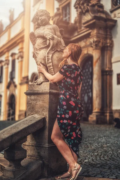 Hermosa modelo de moda cerca de una estatua de ángel. — Foto de Stock