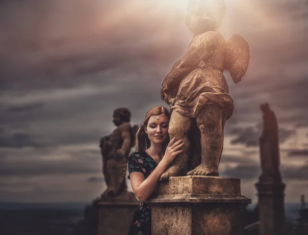 Hermosa modelo de moda cerca de una estatua de ángel. — Foto de Stock