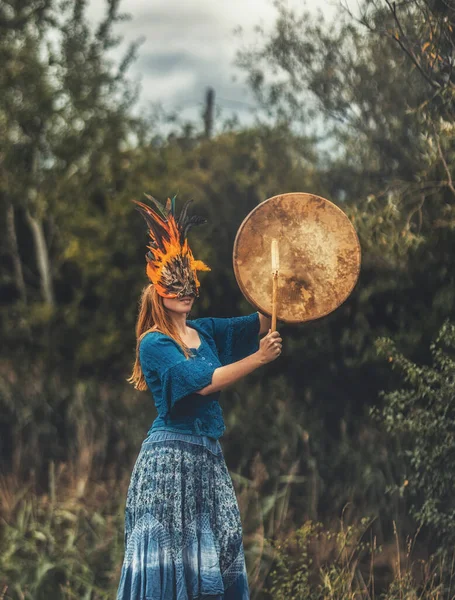 Mooi sjamanistisch meisje spelen op sjamaan frame drum in de natuur. — Stockfoto