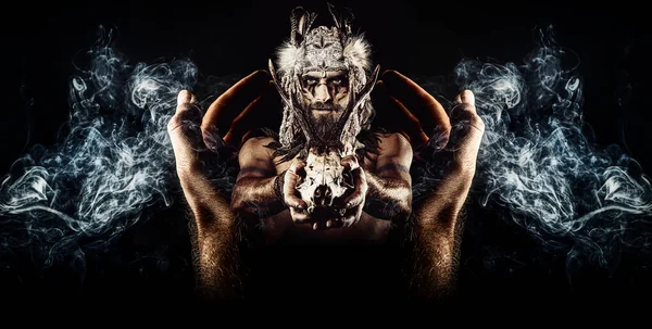 Vacker shamansk man med pannband och rådjur skalle och be händer. — Stockfoto