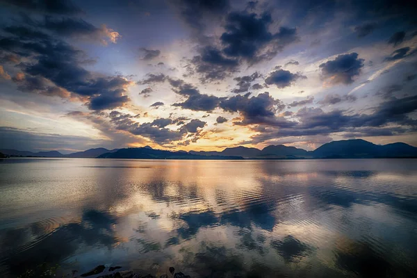 Sonnenuntergangslandschaft, See mit schönen Wolken im Hintergrund. — Stockfoto