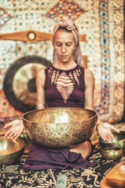 Tibet kâsesinin meditasyon seslerine dalmış ruhani kız..