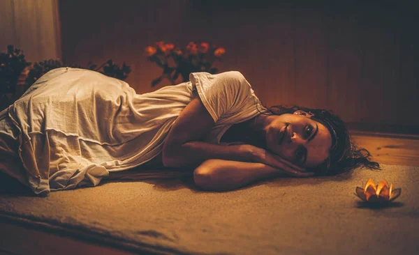 Relaxar mulher no chão pela vela. — Fotografia de Stock