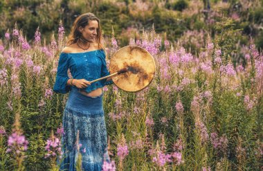 Şaman çerçeveli davul çalan güzel bir şaman kız..