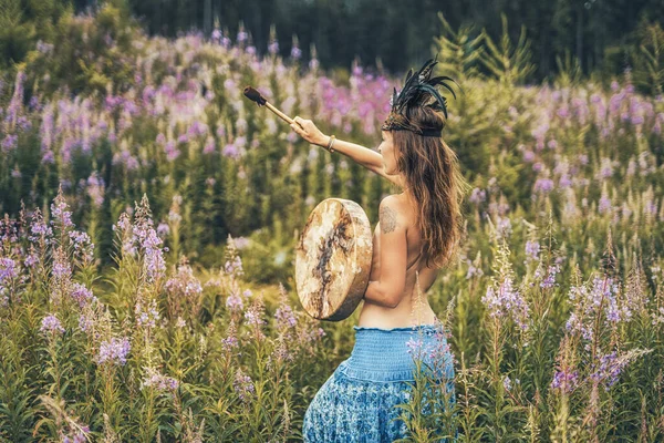 Beautiful shamanic girl playing on shaman frame drum in the nature. — Stock Photo, Image