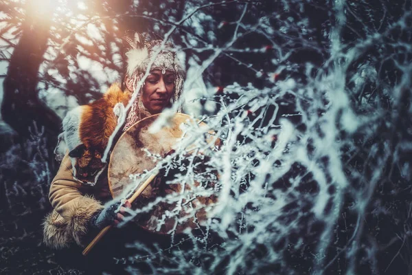 Schönes schamanisches Mädchen, das auf einer schamanischen Rahmentrommel in der Natur spielt. — Stockfoto