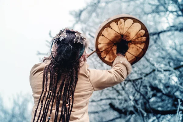 Bela garota xamânica jogando no tambor quadro xamã na natureza. — Fotografia de Stock