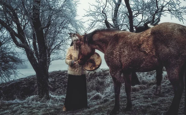 Mulher xamã na paisagem de inverno com seu cavalo. — Fotografia de Stock