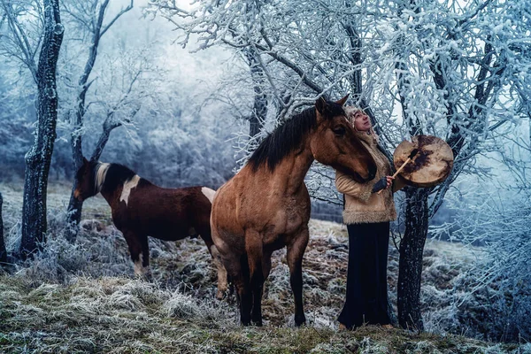 Mulher xamã na paisagem de inverno com seu cavalo. — Fotografia de Stock