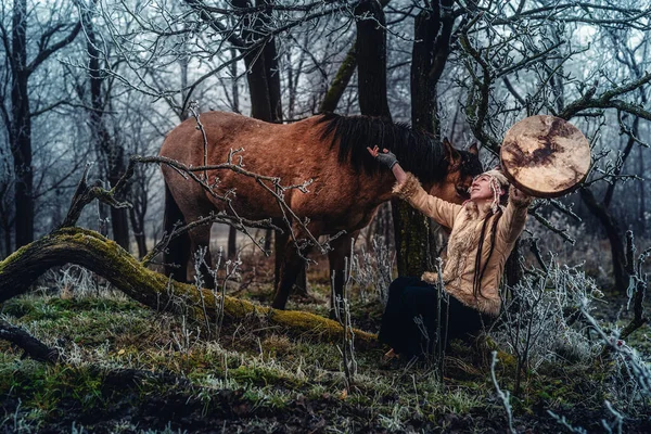 Mulher xamã na paisagem de inverno com seu cavalo. — Fotografia de Stock