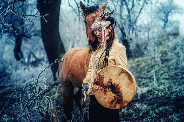 Шаманка в зимнем пейзаже со своей лошадью. — стоковое фото