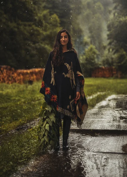 Kadın yağmurda ısırgan otu topluyor.. — Stok fotoğraf