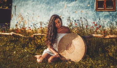 Şaman çerçeveli davul çalan güzel bir şaman kız..