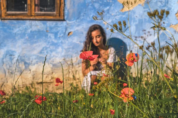 Exotisk kvinna på gården med blommor. — Stockfoto