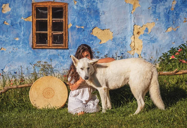 Bella ragazza sciamanica che gioca sul tamburo telaio sciamano nella natura. — Foto Stock