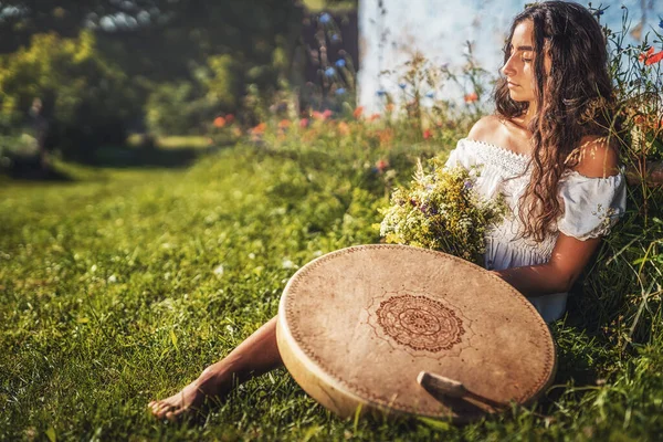 Vacker shamansk flicka spelar på schaman ram trumma i naturen. — Stockfoto