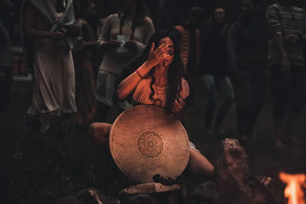 Mooi sjamanistisch meisje spelen op sjamaan frame drum in de natuur. — Stockfoto