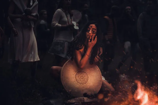 Mooi sjamanistisch meisje spelen op sjamaan frame drum in de natuur. — Stockfoto