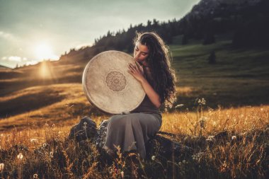 Şaman çerçeveli davul çalan güzel bir şaman kız..