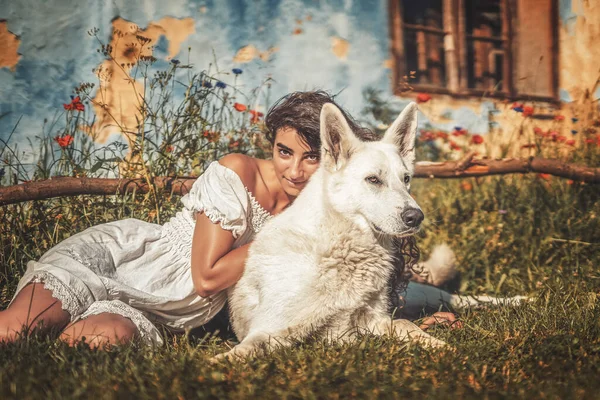 Mujer y perro en el prado al atardecer. —  Fotos de Stock