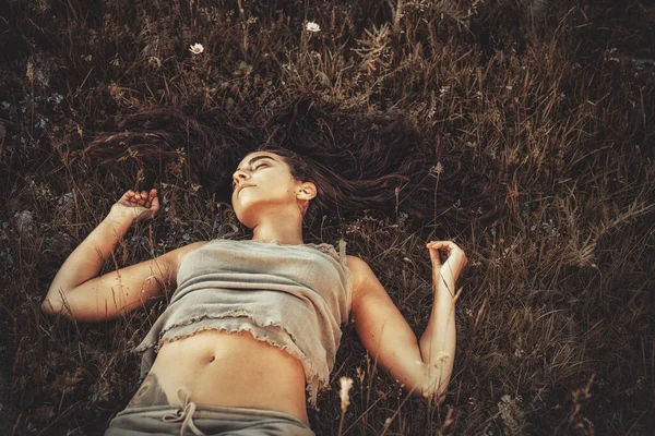 Pretty young woman is lying on a mountain meadow. — Stock Photo, Image