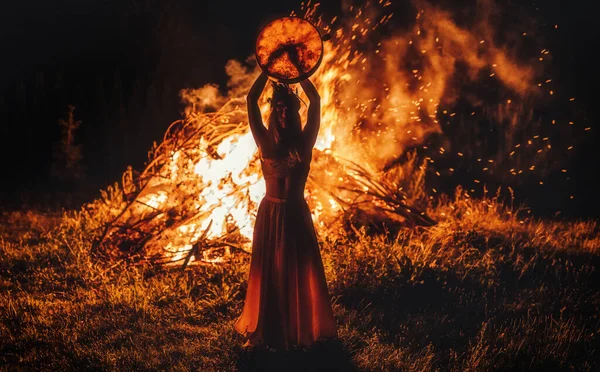 Beautiful shamanic girl playing on shaman frame drum in the nature. — Stock Photo, Image