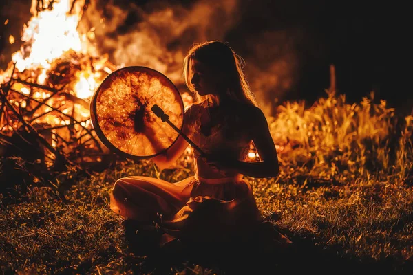 Schönes schamanisches Mädchen, das auf einer schamanischen Rahmentrommel in der Natur spielt. — Stockfoto