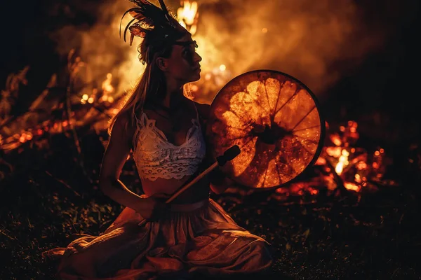 Mooi sjamanistisch meisje spelen op sjamaan frame drum in de natuur. — Stockfoto