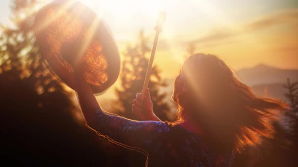 Beautiful shamanic girl playing on shaman frame drum in the nature. — Stock Video