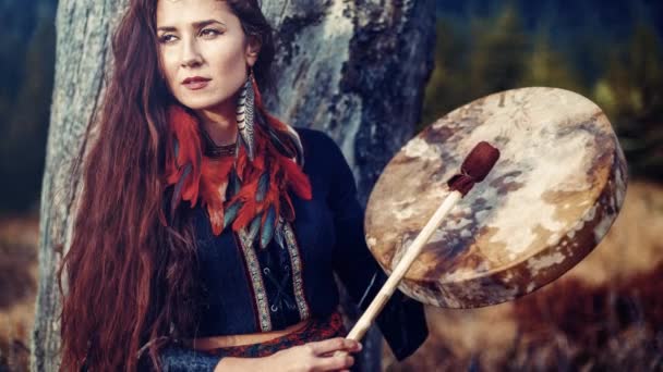 Piękna szamanka dziewczyna gra na szaman ramki bęben w przyrodzie. — Wideo stockowe