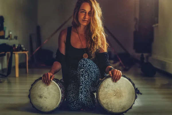 Beautiful young girl playing on djembe. — Stock Photo, Image