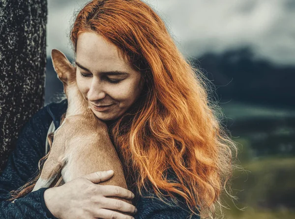 小さな犬を腕に持つ女性は. — ストック写真