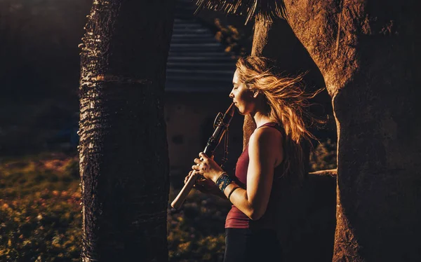 Chica jugando en chamán flauta en la naturaleza. —  Fotos de Stock