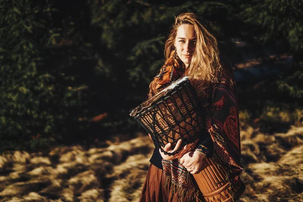 Belle fille chamanique jouer sur le tambour dans la nature. — Photo