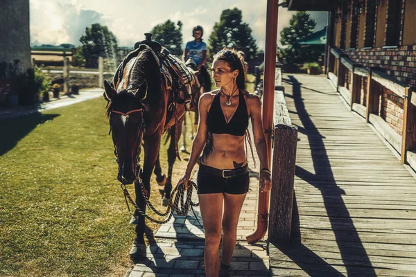 Mädchen trainiert Pferd an einem schönen Sommertag. — Stockfoto