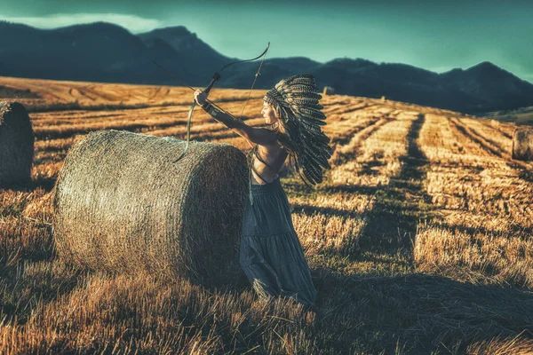 Beautiful shamanic girl in the nature with a bow. — Stock Photo, Image