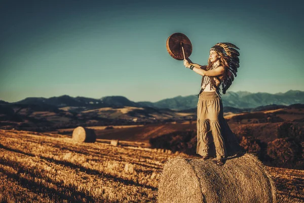 Mooi sjamanistisch meisje spelen op sjamaan frame drum in de natuur. — Stockfoto