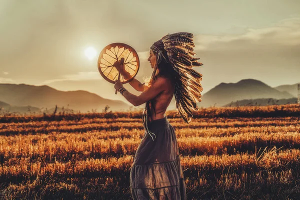 Vacker shamansk flicka spelar på schaman ram trumma i naturen. — Stockfoto