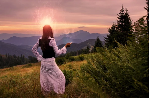 Mujer mística en vestido antiguo solo en un paisaje romántico atardecer —  Fotos de Stock