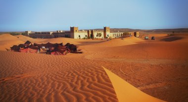 Bir Arap kampıyla bir antik Arapça kale yakınında parlayan dunes üzerinde renkli çadır Fas bir çöl sahne