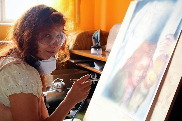 Une jeune femme peignant avec un équipement aérographe — Photo