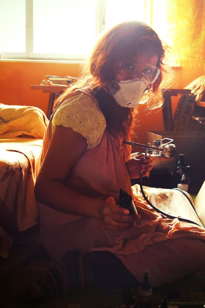 Une jeune femme peignant avec un équipement aérographe — Photo